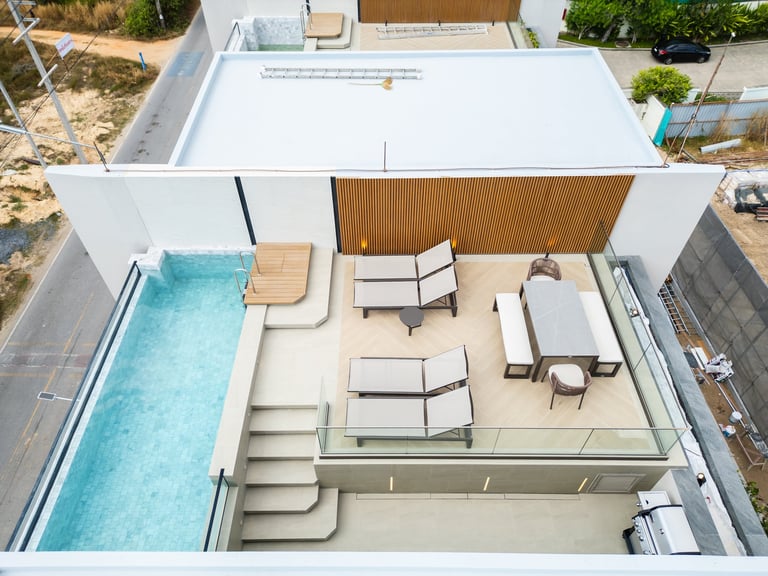 Aerial view of modern residential home with swimming pool, open patio, and outdoor furniture layout