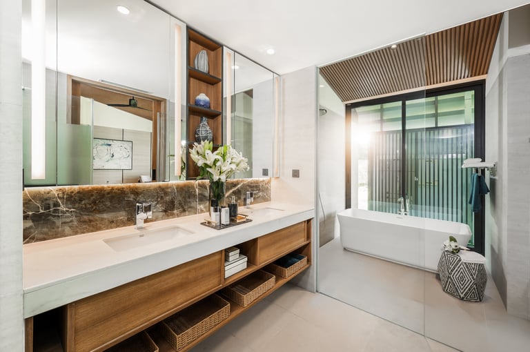 Modern bathroom with double sink vanity, marble backsplash, wooden cabinetry, soaking tub, and large mirror with decorative lighting.