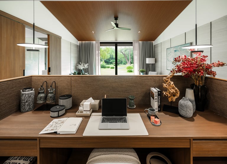 Modern home office with wooden desk, laptop, and decorative accessories against white walls with wood accent ceiling and large window.