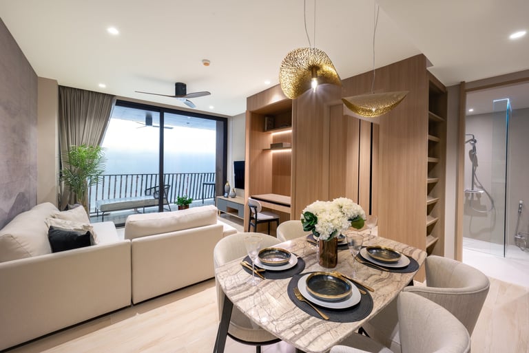 Modern luxury apartment interior featuring dining table, cream sofa, wood cabinetry, and floor-to-ceiling windows with balcony view