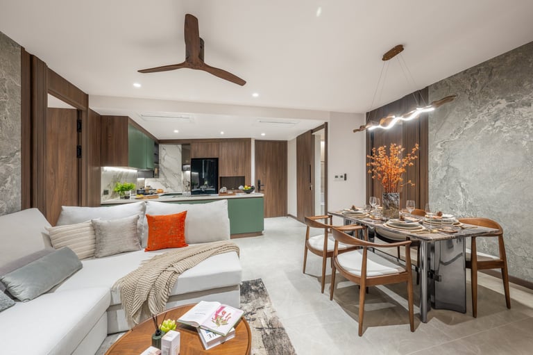 Modern open-concept apartment with white sofa, wooden dining table, kitchen with green cabinetry, and ceiling fan