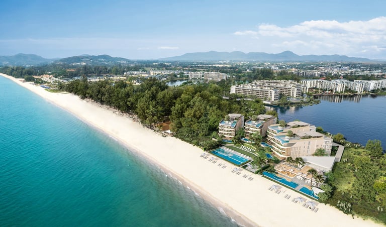 Tropical beachfront resort with turquoise water, white sand, and coastal city with mountains